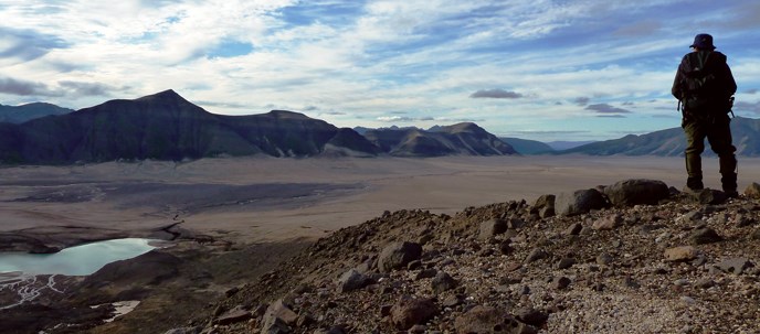 A hiker admires the view of the Valley of Ten Thousand Smokes from the slopes of Mount Mageik.