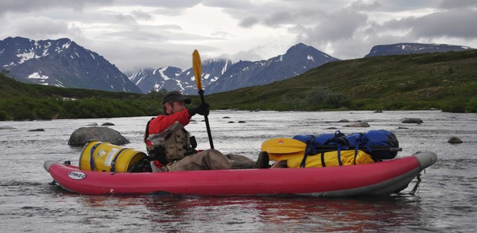 A ranger rafts down American Creek