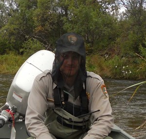 A ranger protects himself from biting insects by wearing a heat net.