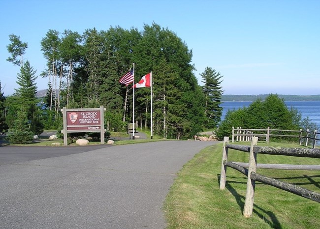 A paved road leading to the entrance sign at Saint Croix Island International Historic Site.