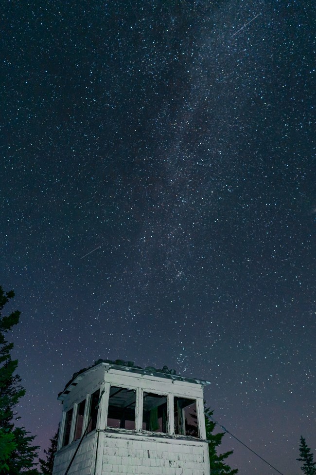 stars above a white four sided wooden structure with three windows per side