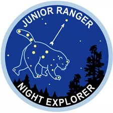 The Night Explorer badge is a round graphic showing the big dipper constellation surrounded by an outline of a bear.
