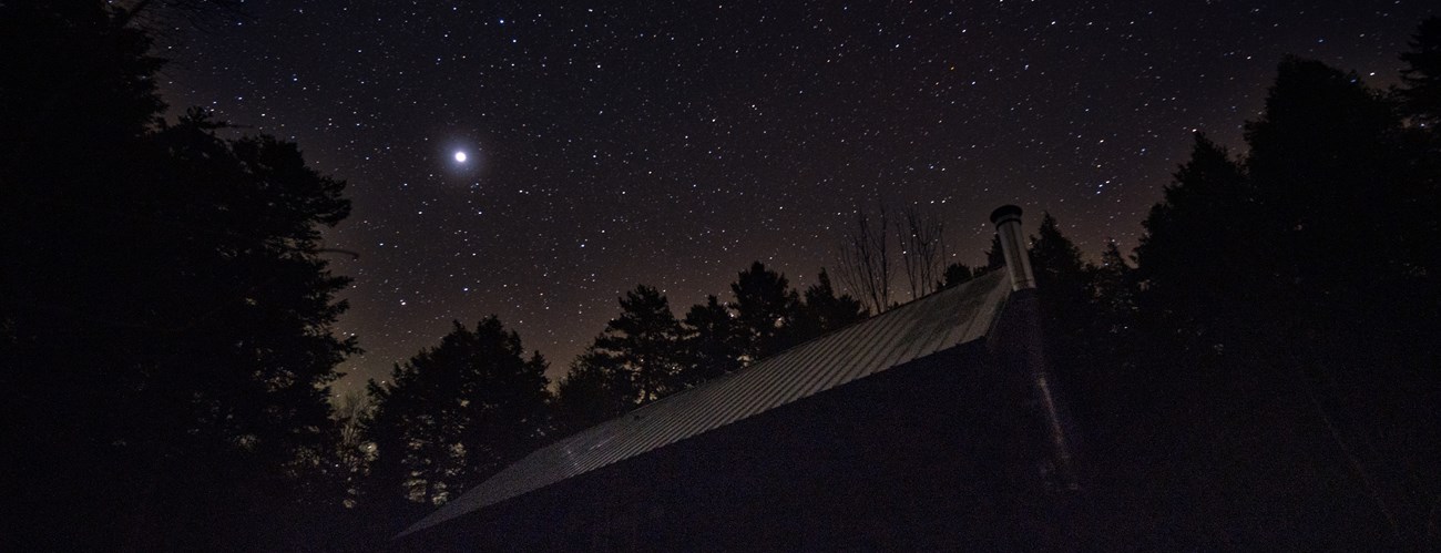 A dark night sky scene of a hut in the monument.