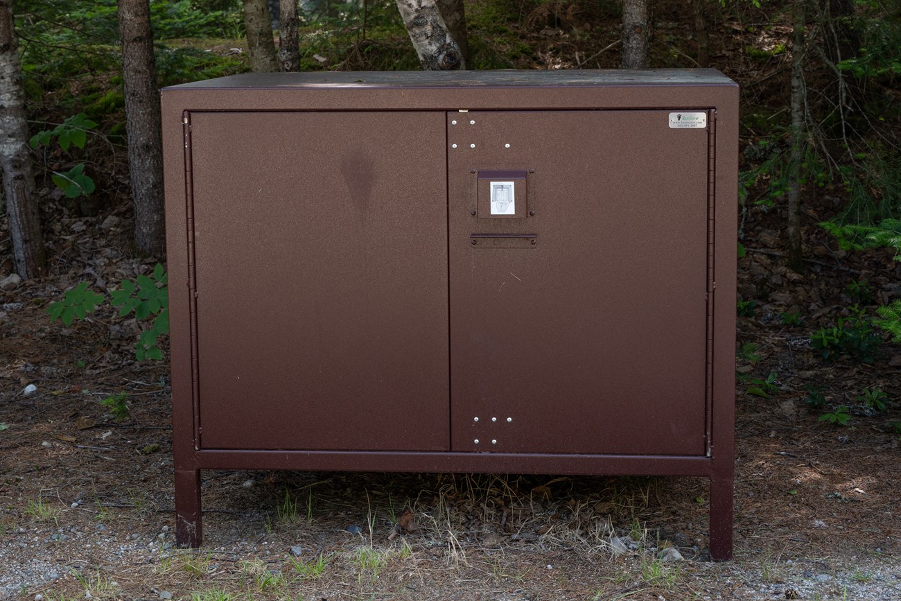 A large metal box for storing food and items saely from bears