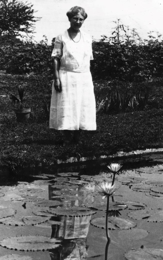 Helen Fowler stands by a small pool