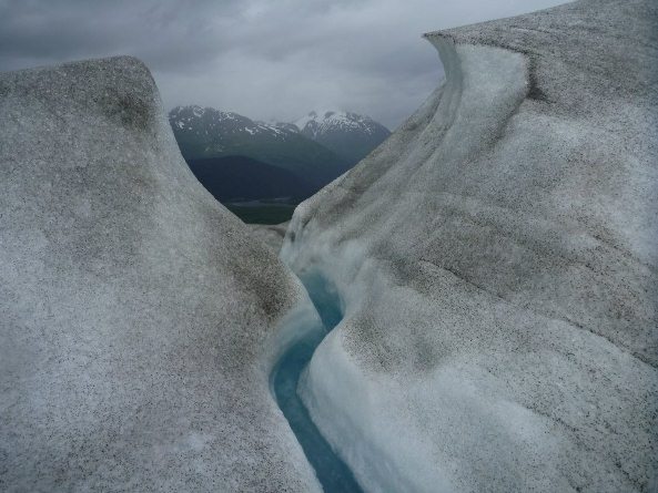 View through a glacial crevass to mountains behind.