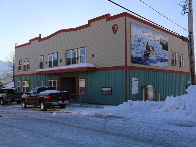 A beige and green building with brown trim