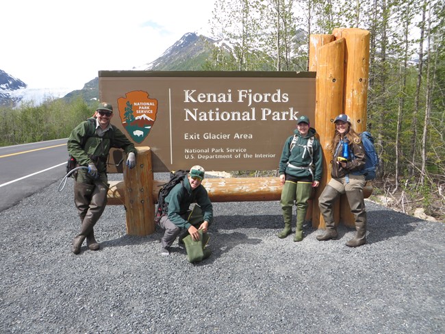 four members of the Invasive Weed team in front of the Kenai Fjords National Park sign