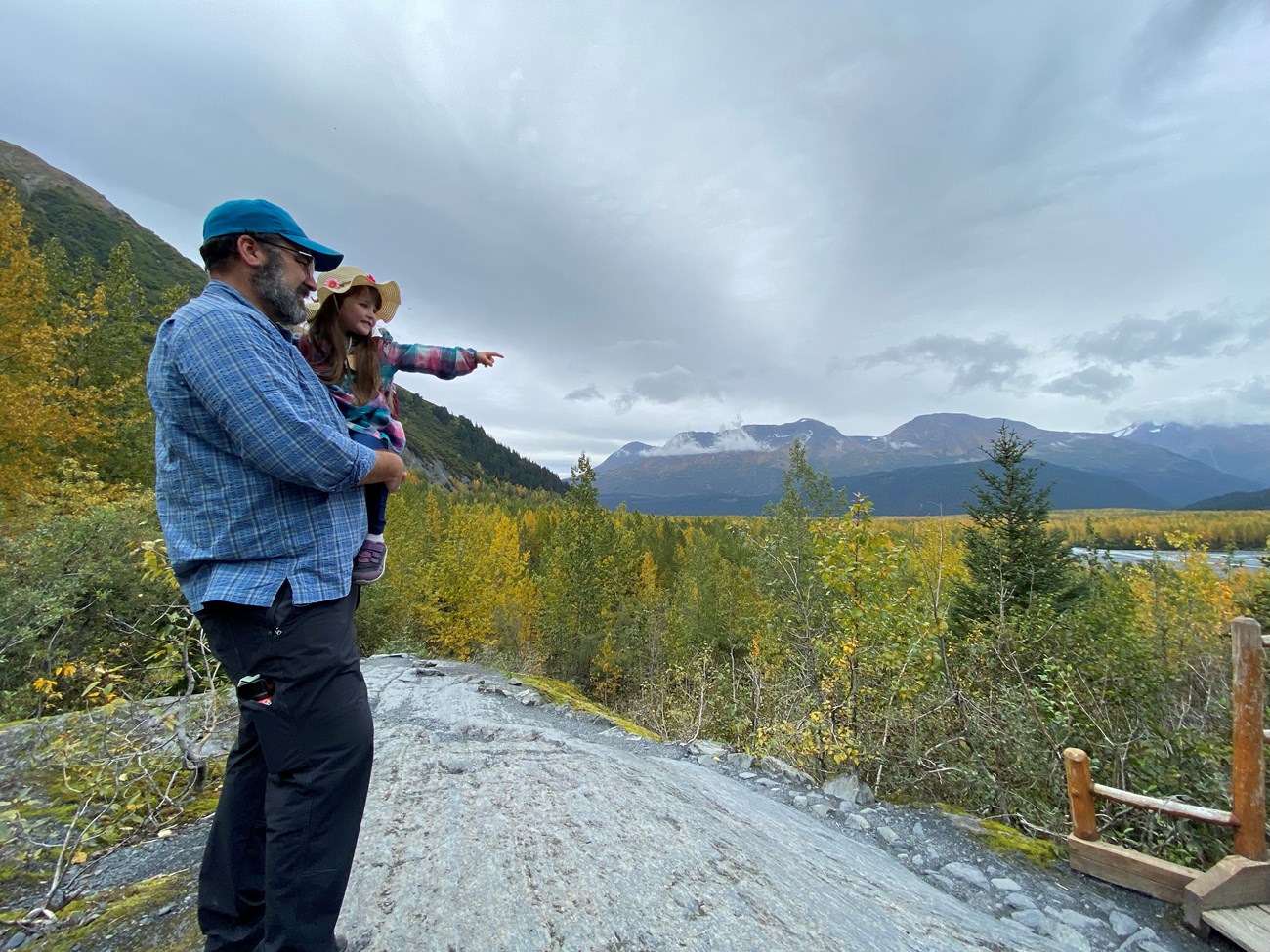 Visitor holding child pointing at viewpoint
