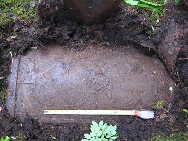 A rusted, metal stove panel recently uncovered from the dirt.