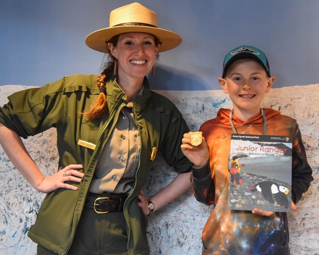 A new Junior Ranger poses with a Park Ranger