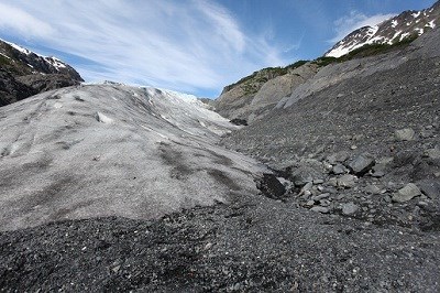 The receding glacier leaves behind bare gravel.