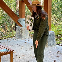 A park ranger pointing towards the ground