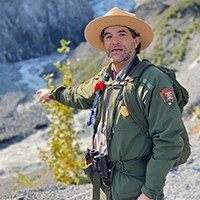 A park ranger pointing out the outflow from Exit Glacier