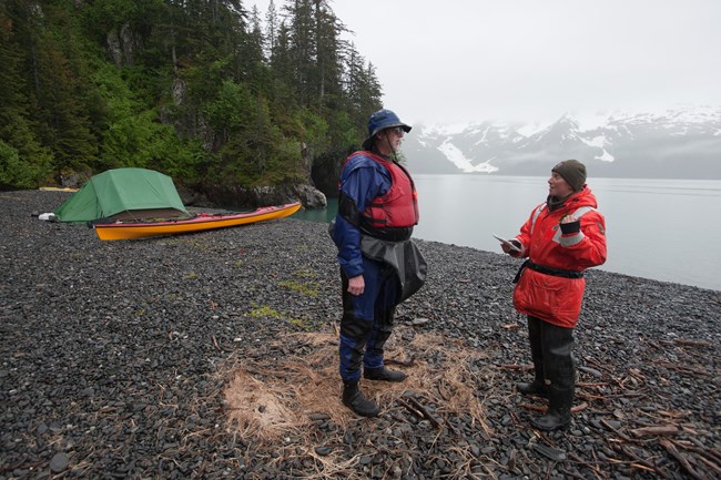 A law enforcement ranger speaks with a visitor on the coast