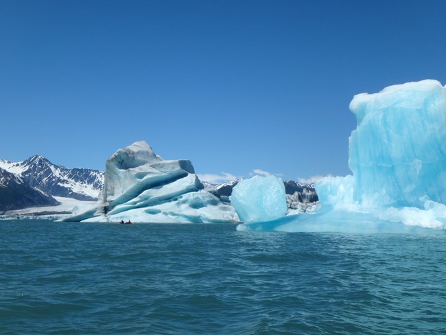 Blue icebergs floating in water