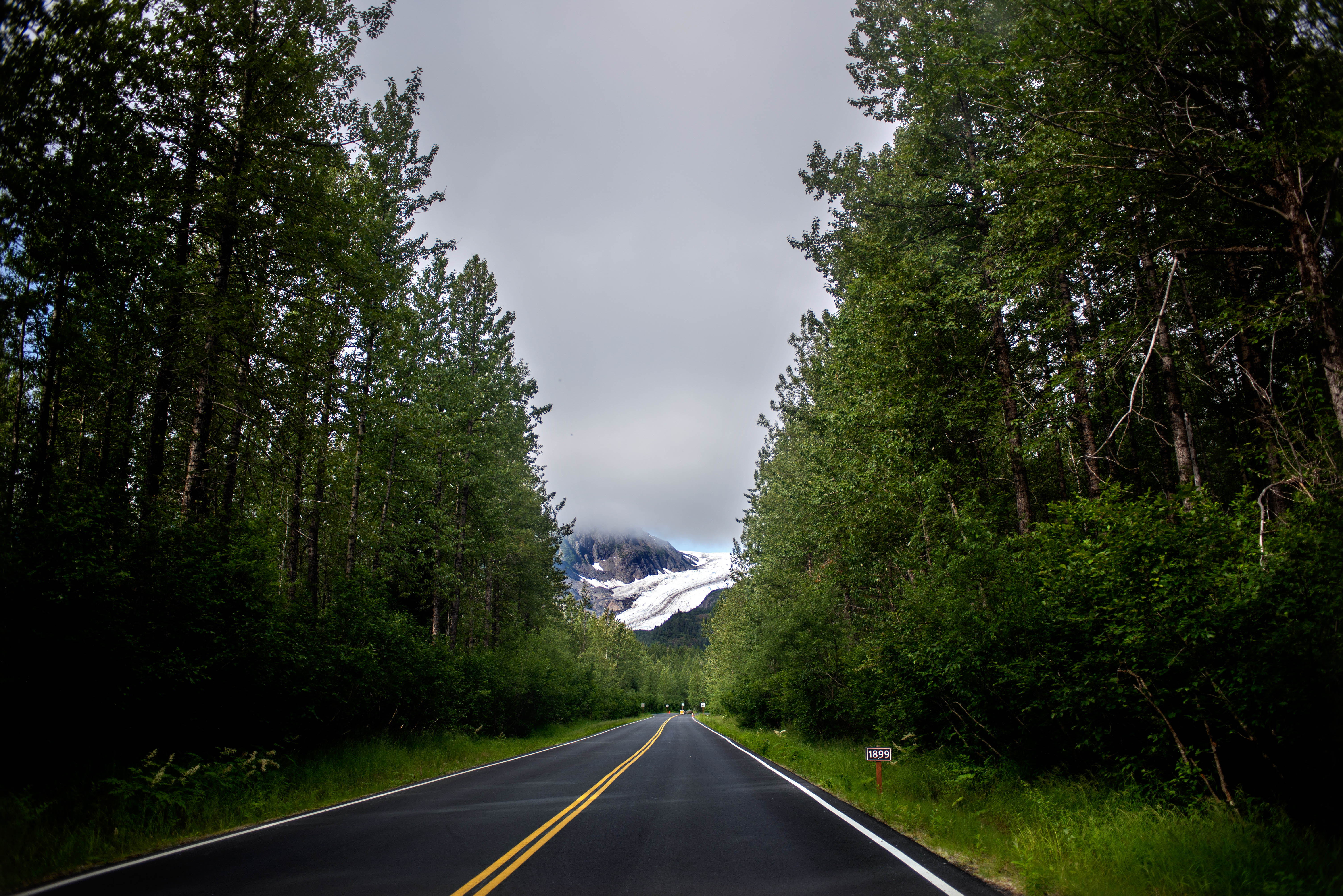 A road with a glacier in the far distance