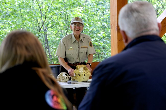 Volunteer talking about bear skulls with visitors