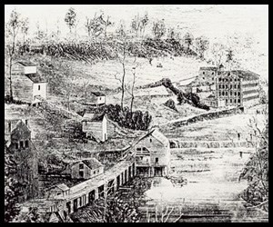 Black and White photo: Scattered multi-story buildings dot the side of a hill.