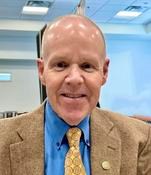 Man in suit with blue shirt and yellow tie