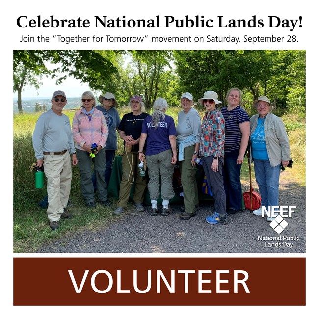A group of park volunteers pose for a photo surrounded by trees and grass.