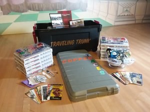 An assortment of items including brochures and snap circuit kits surround a trunk that says "Copper TRACES Traveling Trunk."