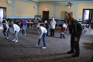 Youth and a ranger mimic dance moves they are watching.