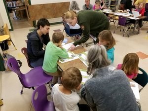 A ranger helps young people with an activity.