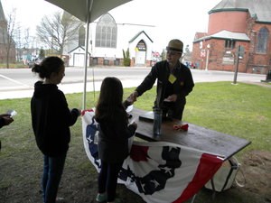 A student takes a piece of paper from a park ranger.