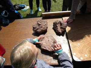 A student touches a rock.