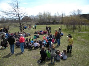 A group of students sits on the ground.