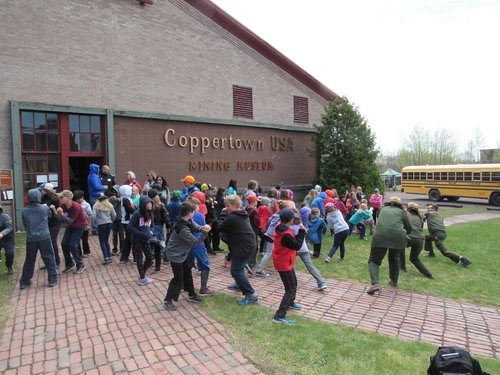 A large group of students mimic park rangers doing different movements.