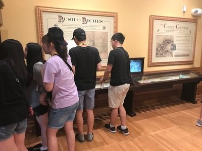 South Korean Group Looks at Exhibits A group of students examine exhibits in a museum.