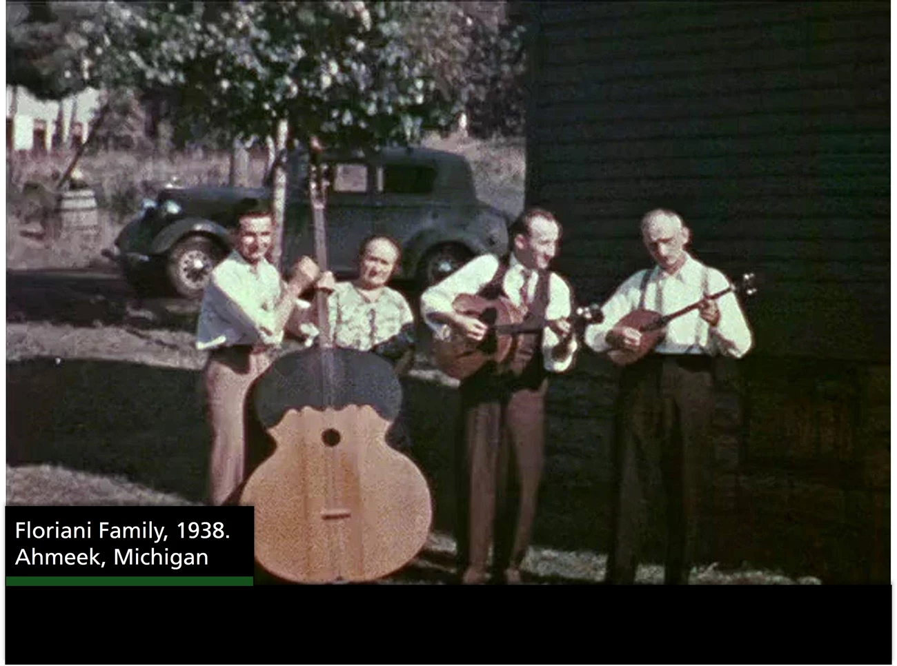 Floriani Family From left to right a man with a large bass instrument, a woman, a man with guitar and another man with another string instrument. A text box reads "Floriani Family, 1938. Ahmeek, Michigan
