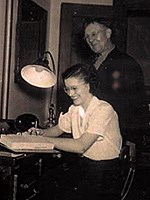 historic photo:Jean Munn and janitor Joe Limback at Jean's desk, November 10, 1945.