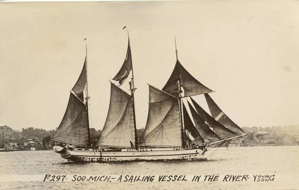 A schooner sails on a lake.