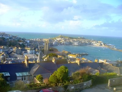 A town with a collection of dense buildings stretches out onto a peninsula surrounded by the sea.