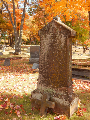 A worn grave marker in a cemetery.