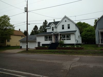 A two-story home with a two-car garge sits next to a street.