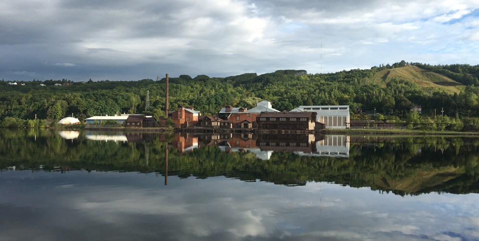 The Quincy Smelter from across the Portage Canal with cloudy skies and glassy water The Quincy Smelter from across the Portage Canal with cloudy skies and glassy water