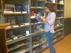 A person reads a book in a store. A person reads a book in a store.