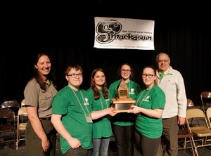 Smackdown Winners 2018 People pose with smiles behind a trophy.