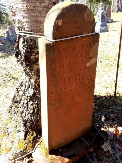 A tall grave marker carved from sandstone.
