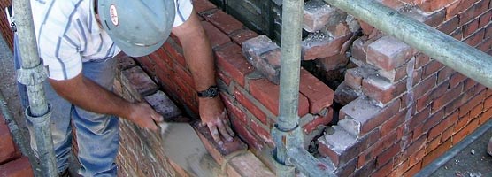 A mason repairs brickwork on the Union Building in Calumet.