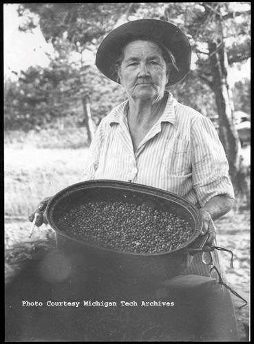 Black and white photo of woman with large blueberry basket