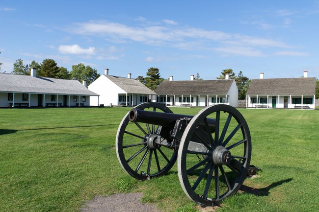 Fort Wilkins with a cannon in the foreground
