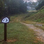 Walking trail with a sign in the left foregroun