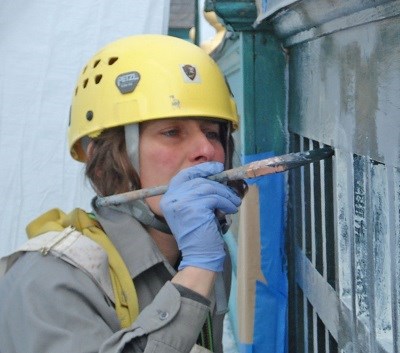 Woman painting a building. Woman painting a building.
