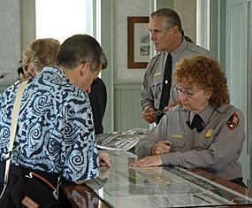 Two rangers provide information to two visitors at an information desk Two rangers provide information to two visitors at an information desk