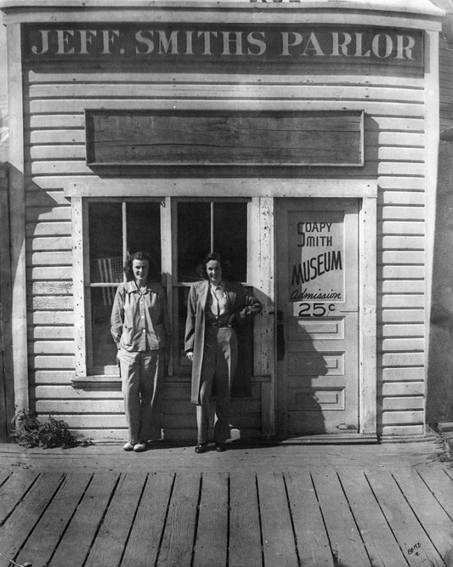 Two women stand in front of a building